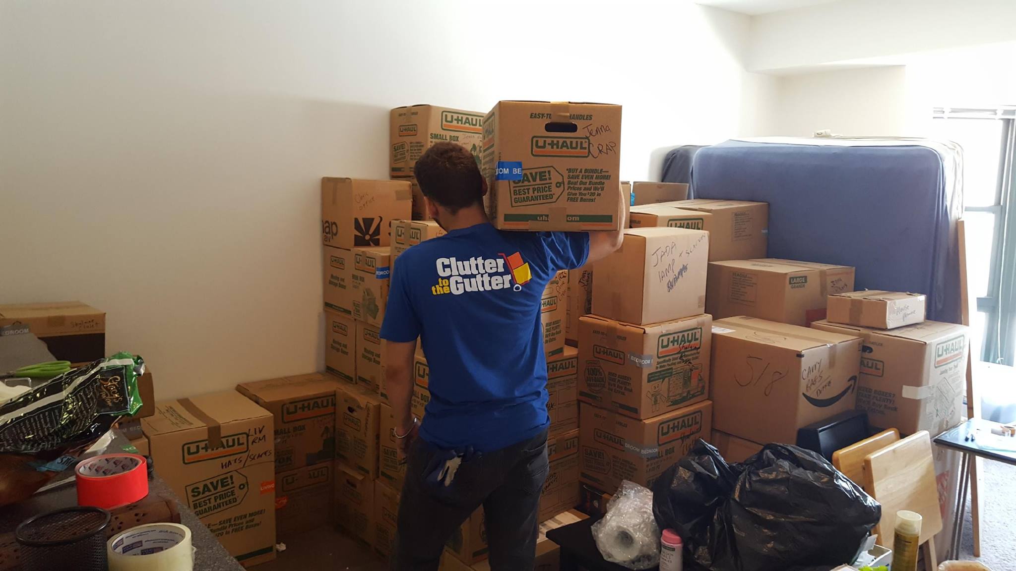 Junk removal crew carrying moving boxes during apartment cleanout - small moves and large item transport